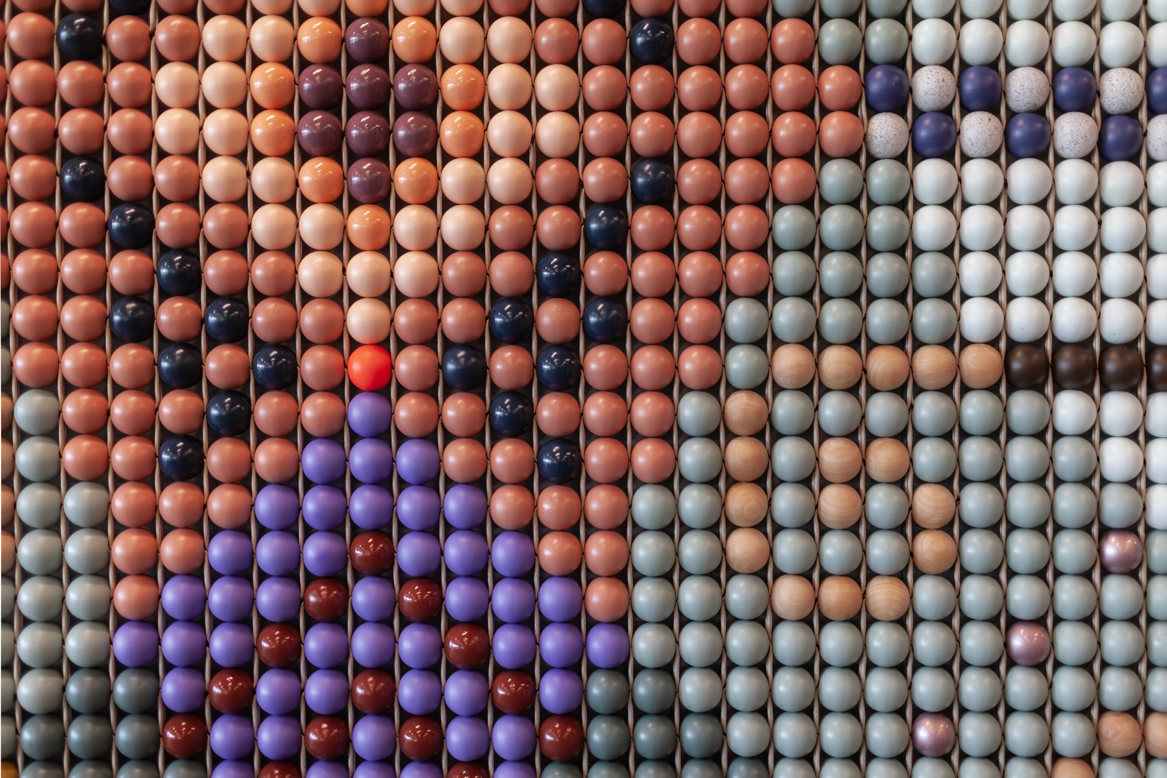Straight-on view of the bead grid in coral, violet, sage and natural wood